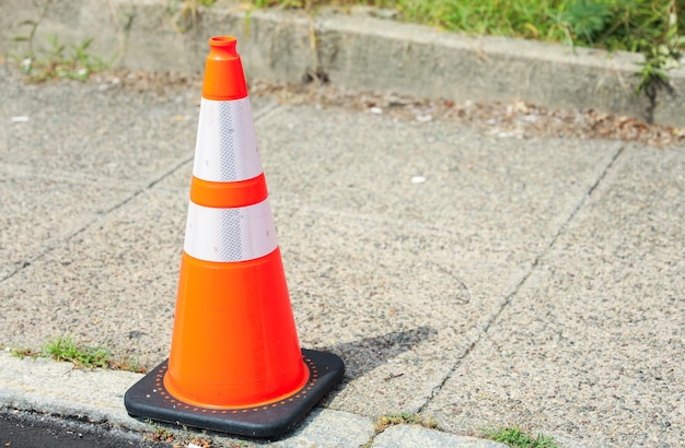 cone de construção laranja em uma estrada, simbolizando cautela de segurança e trabalho contínuo em uma construção