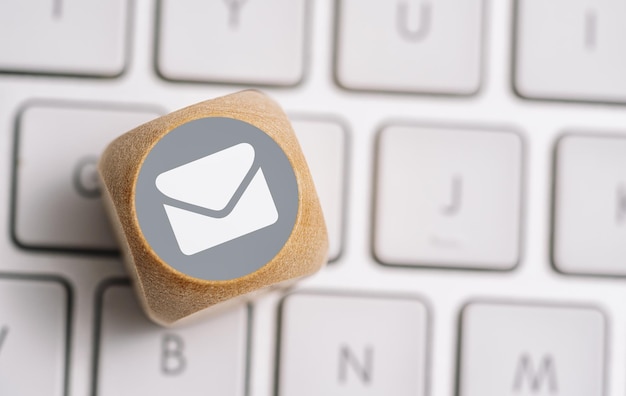 Ícone de e-mail em um cubo de madeira em um teclado Imagem de conceito de métodos de contato e comunicação