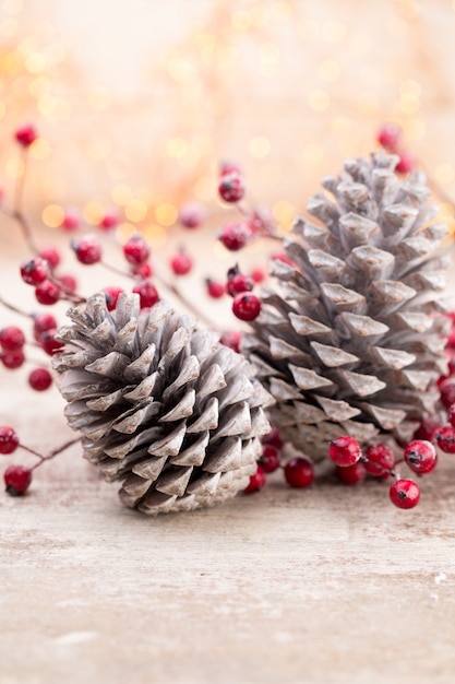 Cone de natal com bagas vermelhas em um fundo de bokeh