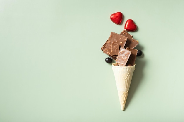 Cone de waffle com chocolate plano, vista superior em fundo verde pastel