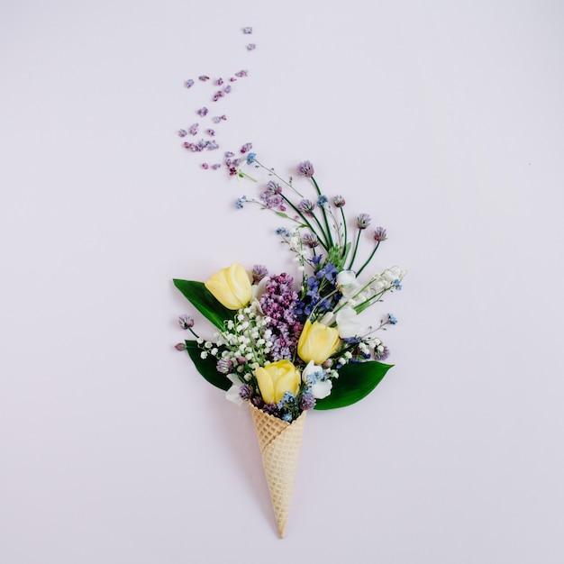 Cone de waffle com flor lilás, lírio do vale e buquê de tulipas