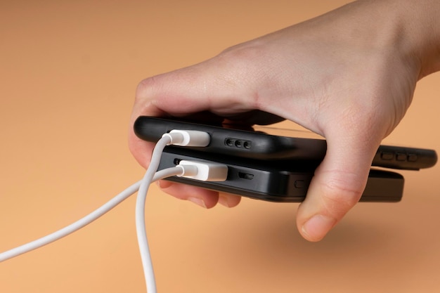 Conectando o acumulador de banco de potência portátil usb e a cor preta do telefone na mão