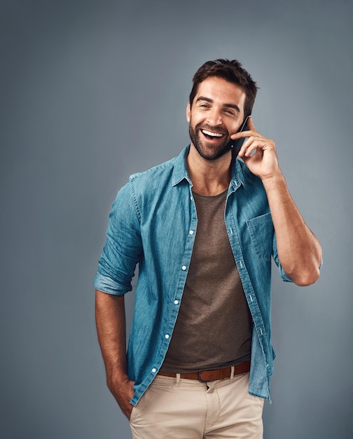 Conectar-se com outras pessoas nos mantém felizes Foto de estúdio de um jovem bonito usando um telefone celular contra um fundo cinza