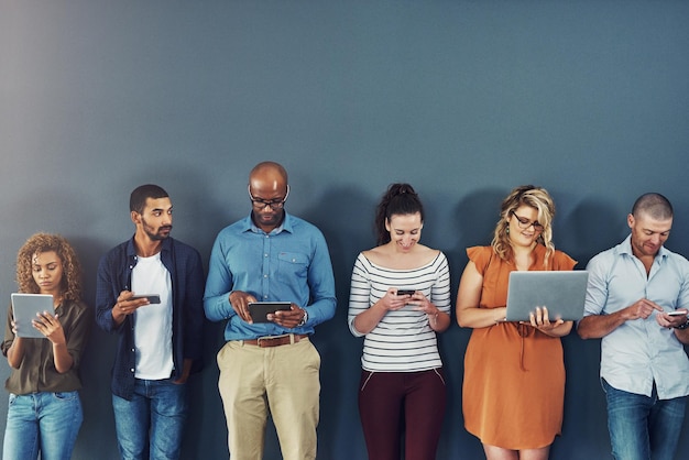 Conectividad tecnológica y equipo de personas de negocios en la pared juntos en teléfono, tableta o portátil comunicación en Internet y empleados creativos con contacto en el sitio web red digital o aplicación móvil