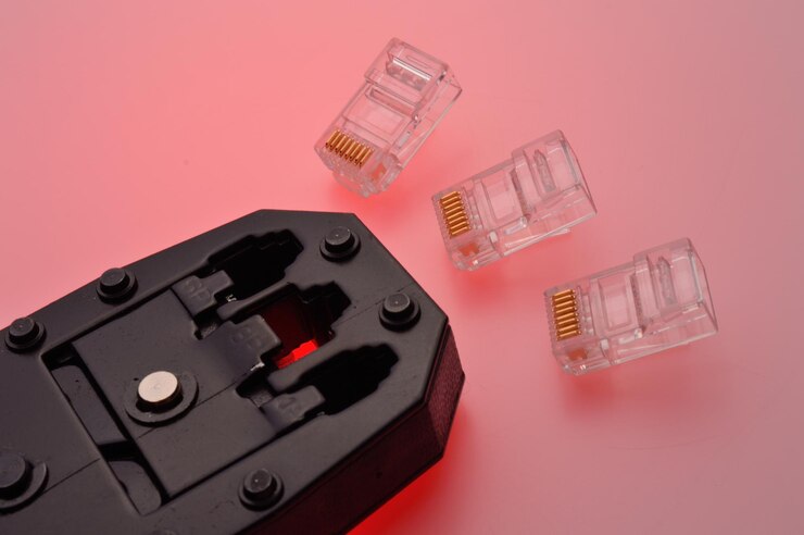 Foto un conector rg45 para un cable de internet y un engarzador de par trenzado yacen sobre un fondo multicolor primer plano