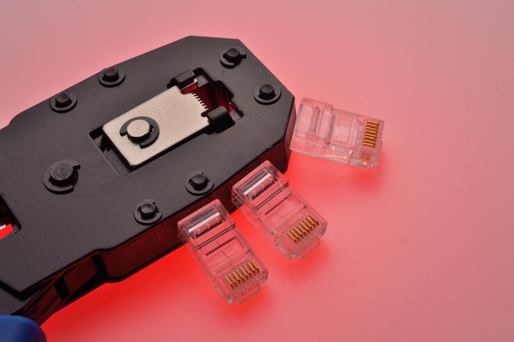 Foto un conector rg45 para un cable de internet y un engarzador de par trenzado yacen sobre un fondo multicolor primer plano