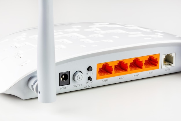 Conectores, botões de controle. portas lan e adsl em um novo roteador Wi-Fi branco com antenas cinza em um plano de fundo branco