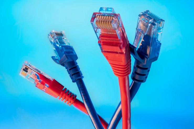 Foto conectores rojo y azul para internet, dos colores de cables de datos sobre un fondo azul.