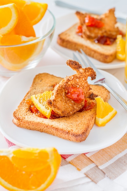 Conejito en forma de pan tostado con mermelada, jugo y té.