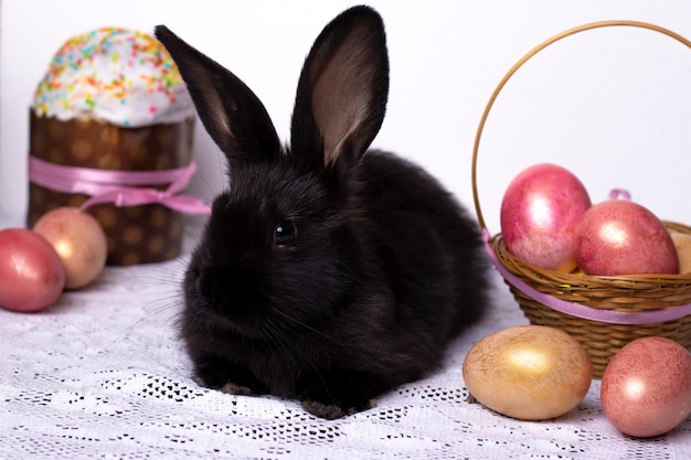 Conejito negro en la composición de Pascua con huevos y pasteles de Pascua
