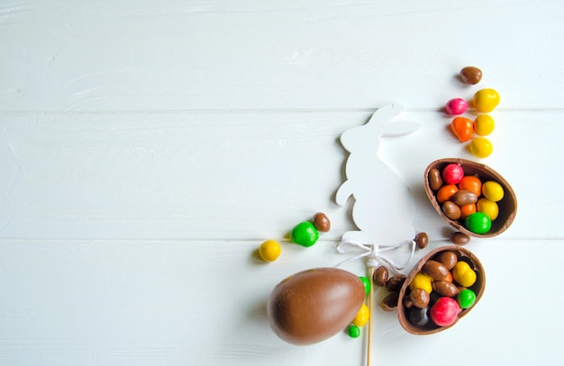 Conejito de Pascua blanco con huevos de chocolate y dulces.