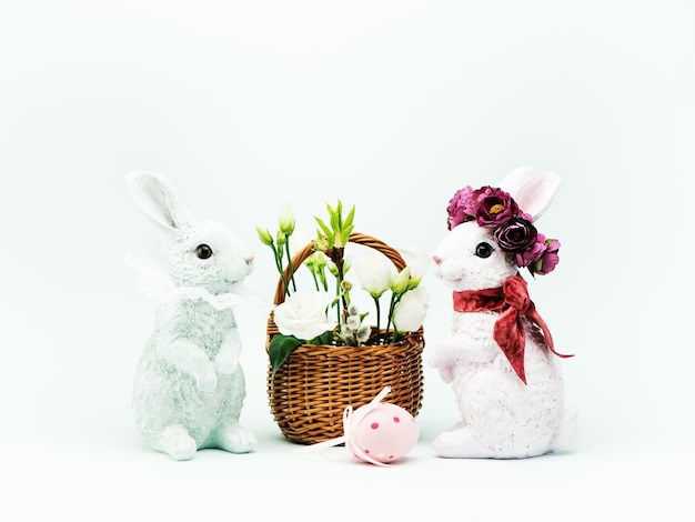 Conejito de Pascua y flores blancas de primavera en una canasta. Tarjeta de felicitación de Pascua feliz