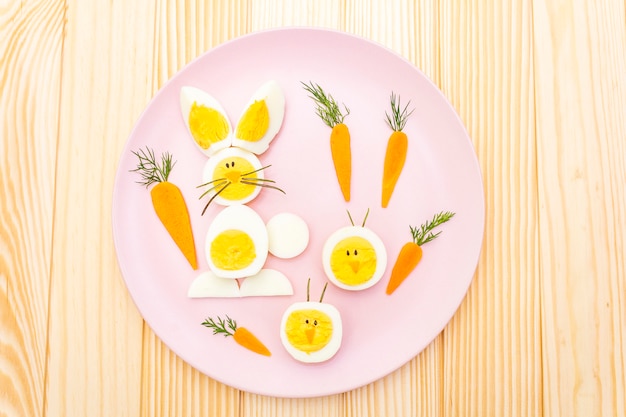 Conejito de pascua y huevos de gallina para niños con zanahorias