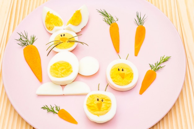 Conejito de pascua y huevos de gallina para niños con zanahorias