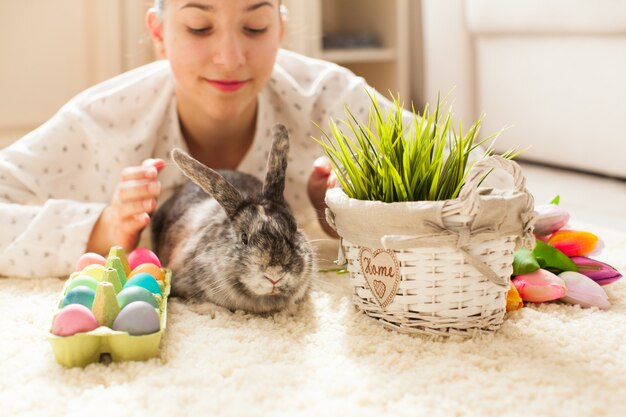 Conejo de Pascua en casa con huevos y pasto verde