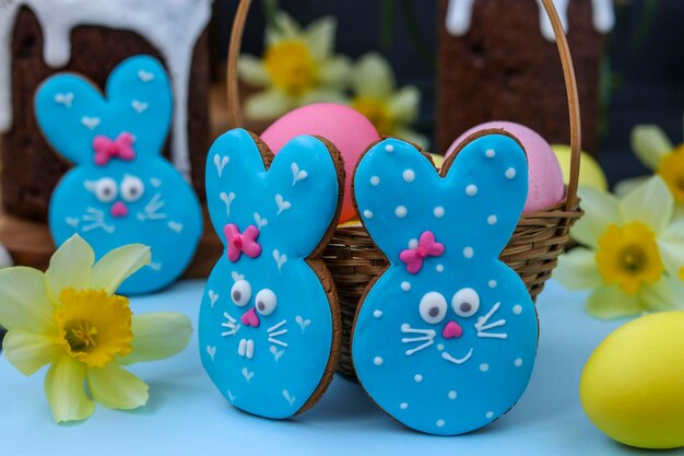 Conejos azules de pan de jengibre en la composición de Pascua con huevos y pasteles de Pascua Orientación horizontal
