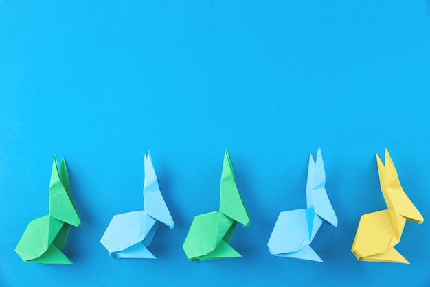 Conejos de Pascua coloridos origami de papel en azul