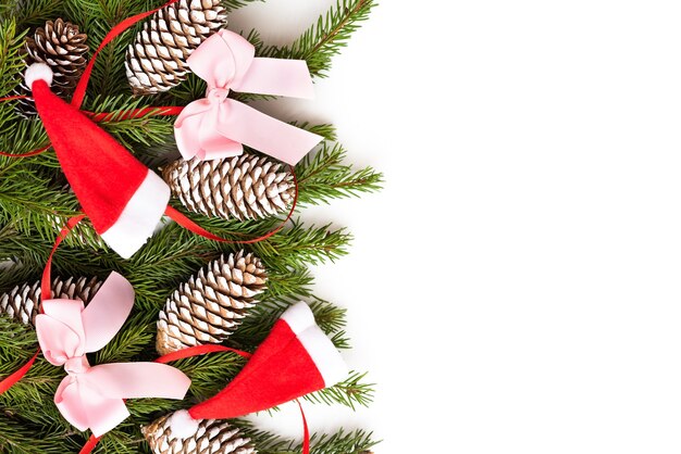 Cones com galhos de pinheiro e vários brinquedos em um fundo branco para o Natal.