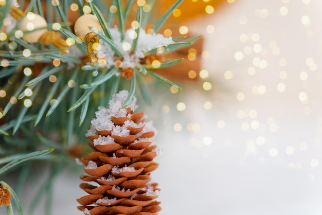 Foto cones de composição de natal na neve bokeh guirlandas neve ramos de abeto.