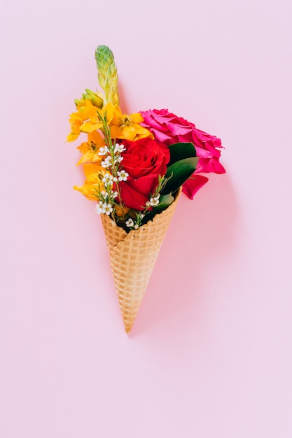 Cones de sorvete plana leigos com buquê colorido em rosa, cópia espaço