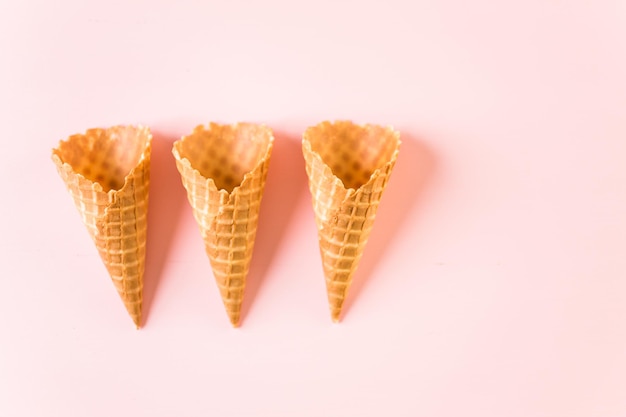 Cones de sorvete waffle vazio em um fundo rosa.