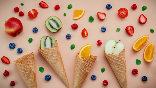 Cones e várias frutas coloridas para o conceito de menu verão e doce.