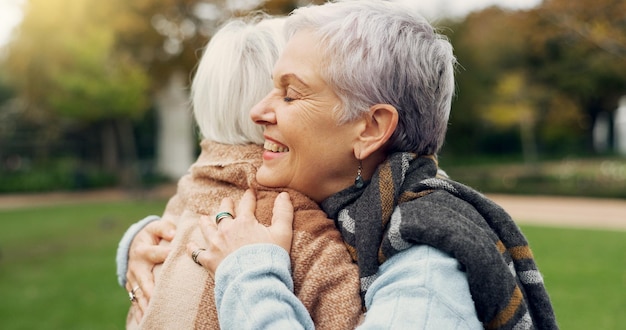 Conexión de amor y mujeres mayores abrazándose por afecto romance y vínculo en una cita al aire libre Compromiso con la naturaleza y pareja de mujeres mayores en la jubilación con un momento íntimo en un jardín o parque