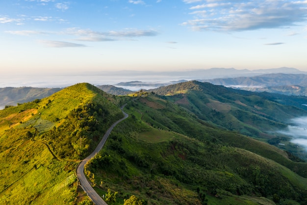 Conexión del camino de la montaña el fondo de la ciudad y del cielo azul en el tiempo de mañana chiang rai Tailandia