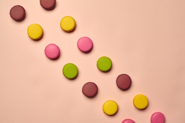 Confecção de macaron colorido ou macaroon com base em merengue doce em fundo rosa Closeup espaço de cópia