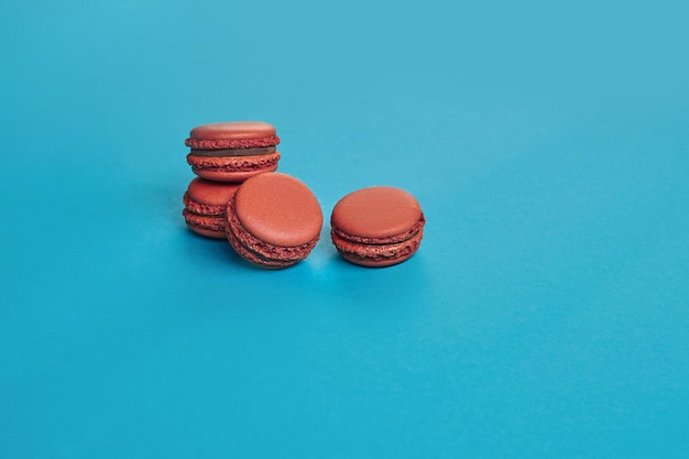 Confecção de macaron colorido ou macaroon doce à base de merengue em fundo azul Closeup espaço de cópia