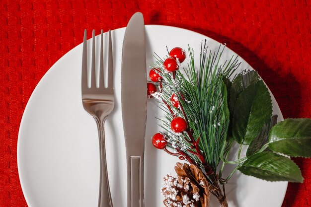 Confecção de mesa de Natal Prato e talheres em guardanapo vermelho Decoração para um jantar festivo