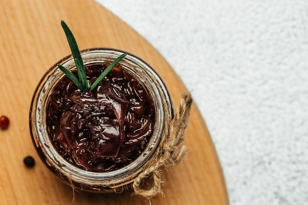 Confeitaria de geléia de marmelada de cebola vermelha em jarra Geléia de legumes em fundo escuro Molho delicioso Cozinha francesa Espaço de fundo de receita de comida para texto