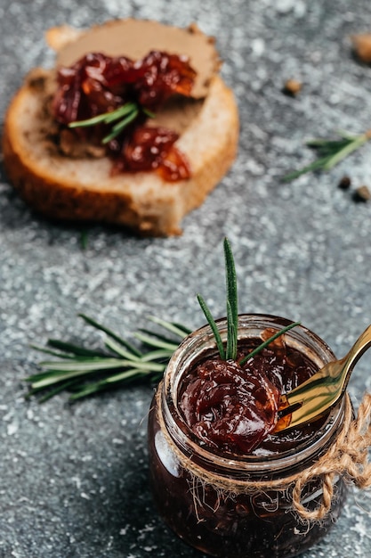 Confeitaria de geléia de marmelada de cebola vermelha em jarra Geléia de legumes em fundo escuro Molho delicioso Cozinha francesa Espaço de fundo de receita de comida para texto