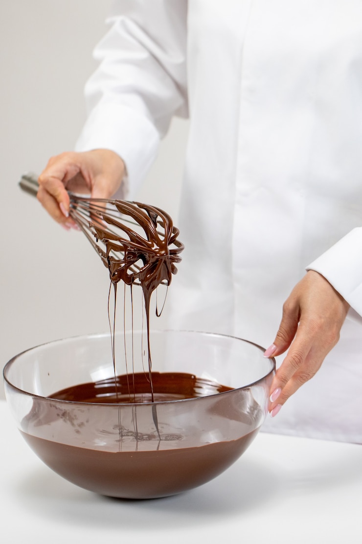 Foto confeiteiro batendo chocolate belga derretido