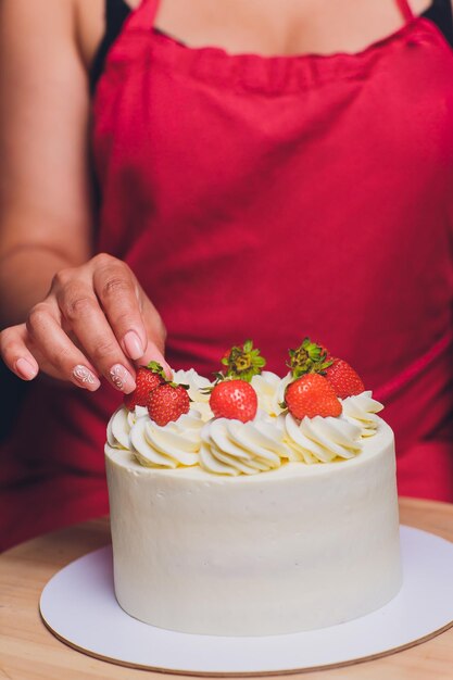 Foto confeiteiro decorado com frutas um bolo de biscoito com creme branco bolo fica sobre uma mesa de madeira o conceito de pastelaria caseira cozinhar bolos