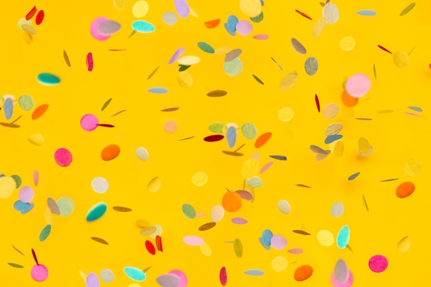 Confete colorido em copyspace de fundo amarelo para texto brilhante e festivo de férias