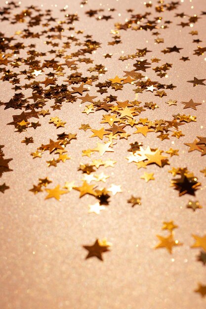 Confetes de estrelas brilhantes espalhados sobre um fundo dourado
