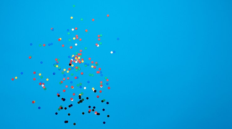 Foto confetes redondos multicoloridos brilhantes espalhados sobre um fundo azul, cenário festivo para aniversário