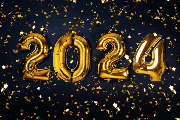 Confeti de estrelas brilhantes e balões de ar de cor dourada de 2024 em um fundo preto