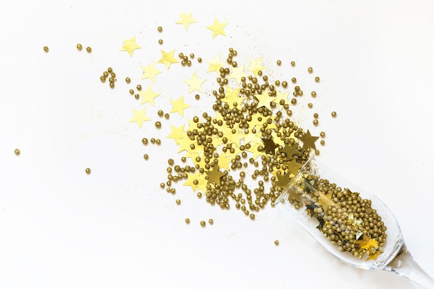 Foto confeti dorado en forma de estrellas derramó copas de champán