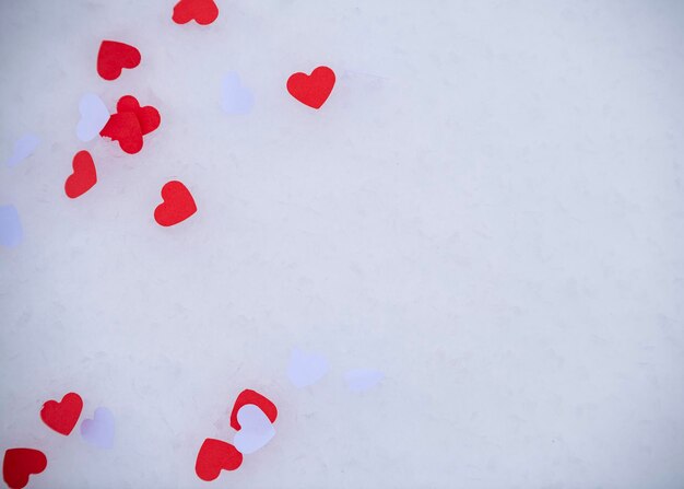 Confeti en forma de corazón tirado en la nieve