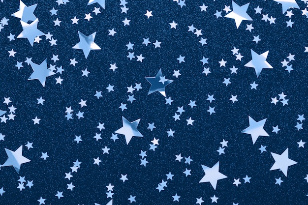 Confeti de forma de estrellas en color azul clásico Fondo festivo de vacaciones Brillo brilla.