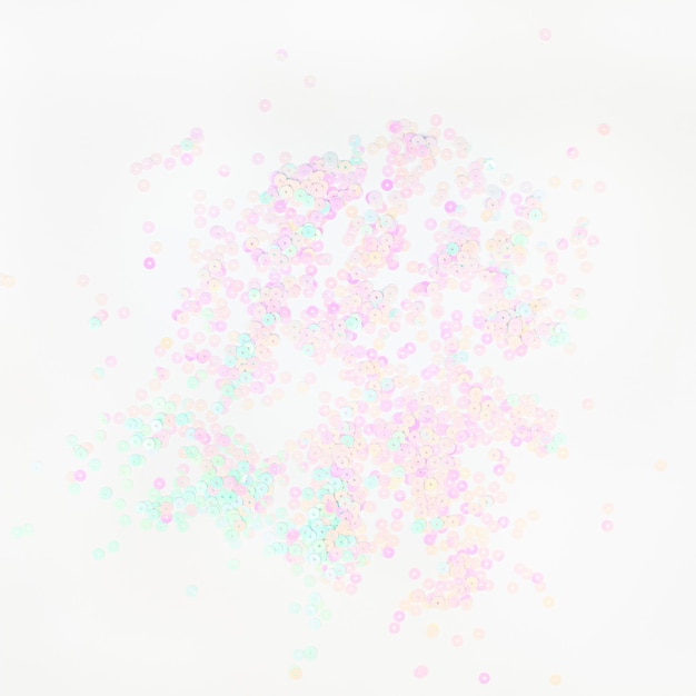 El confeti de perlas en color pastel brilla sobre un fondo blanco