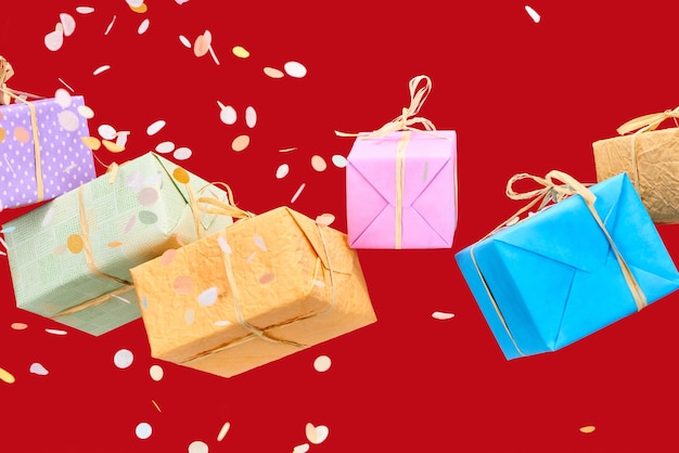 Confeti que cae cerca de coloridas cajas de regalo en rojo