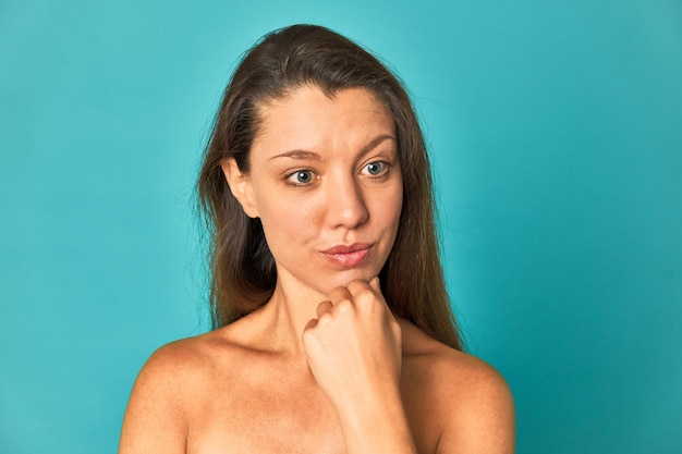 Confiada y cautivadora joven mujer caucásica posando para la cámara con belleza y gracia