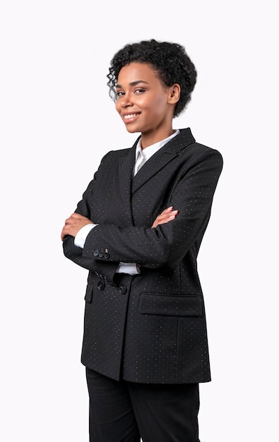 Confiada empresaria afroamericana sonriendo y mirando en el futuro en traje negro aislado en blanco