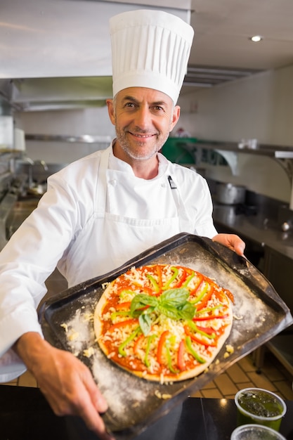 Confiado chef con comida cocinada en la cocina