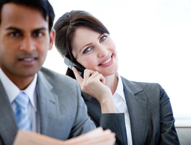 Confiante empresária no telefone sentado em um sofá