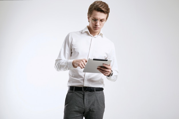 Confiante jovem empresário em camisa trabalhando em tablet digital