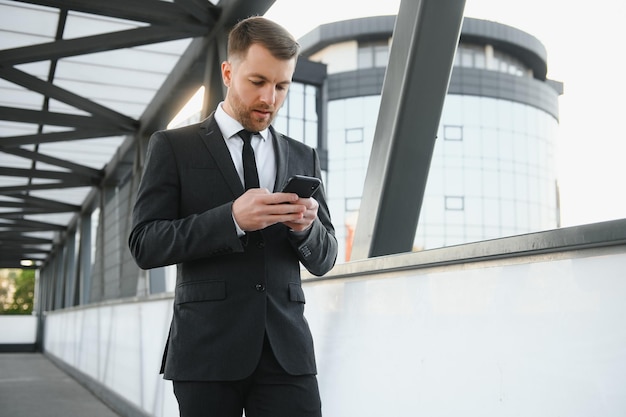 Confiante jovem empresário usando telefone celular na cidade